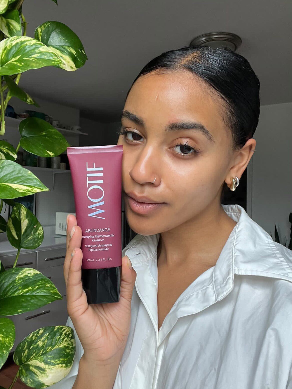 Woman holding the Abundance Plumping Phyto Ceramide Hydrating and Gentle Face Cleanser