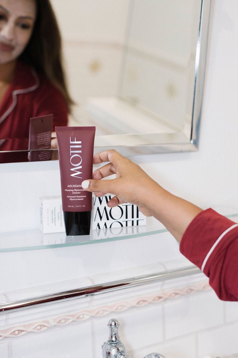 Woman reaching for Abundance Plumping Phyto Ceramide Cleanser for Hydrated and Brightened Skin