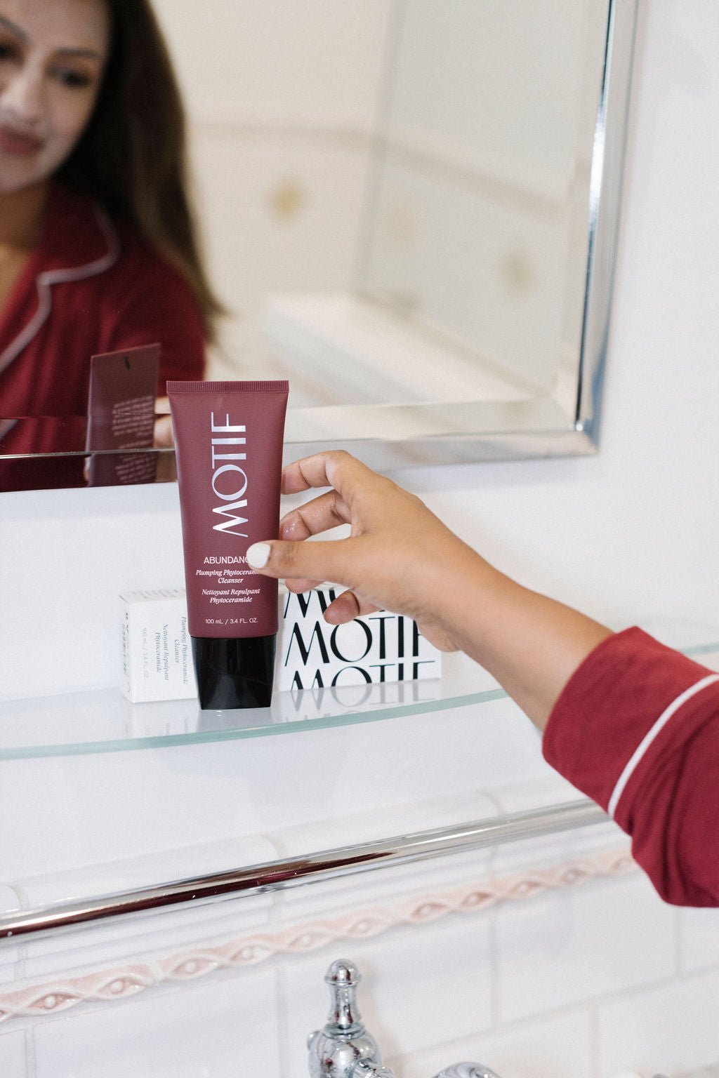 Woman reaching for Abundance Plumping Phyto Ceramide Cleanser for Hydrated and Brightened Skin