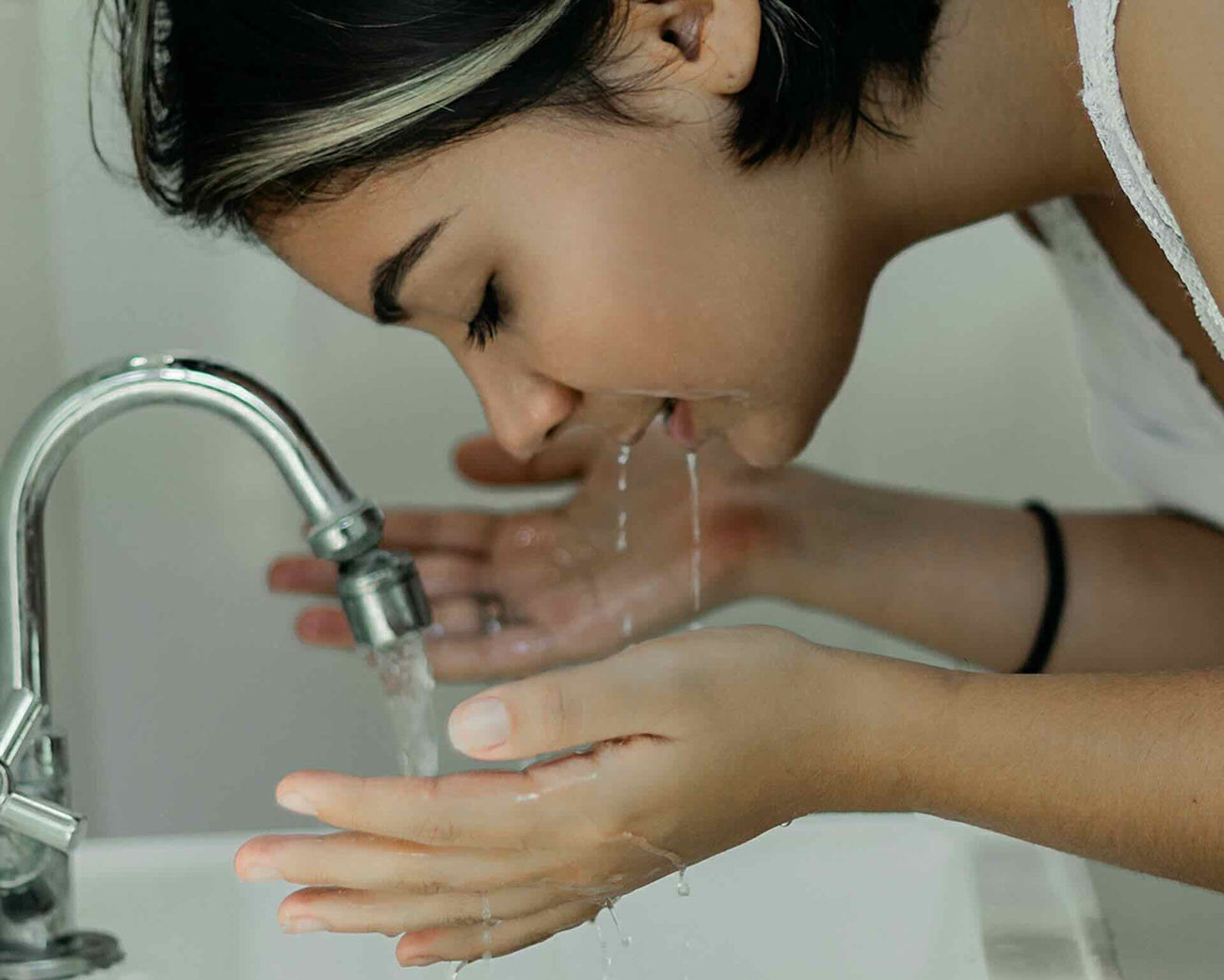 Woman washing her face with a gentle and hydrating face cleanser