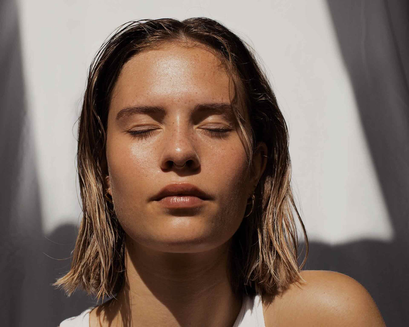 Woman closing eyes and using gentle face cleanser in her Tiktok skin cycling routine
